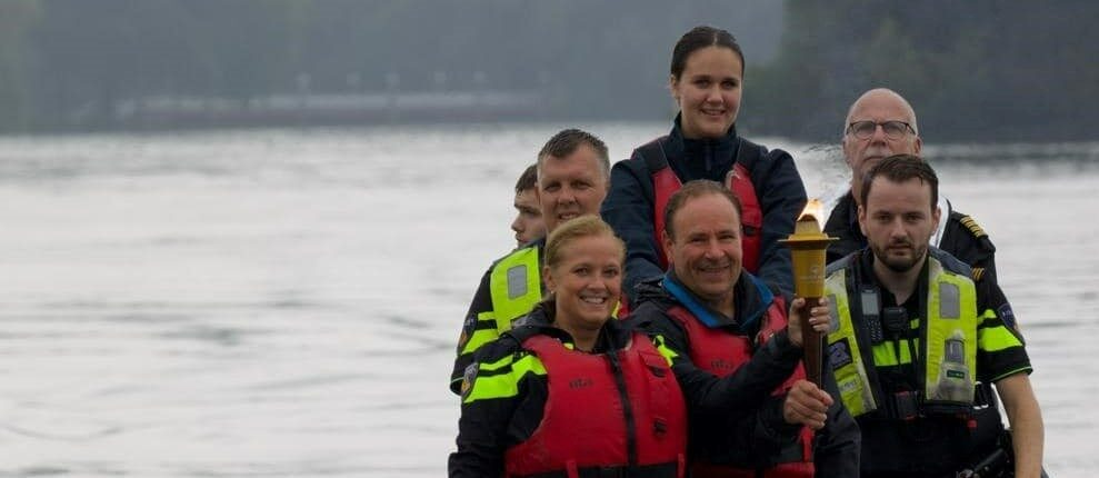 De bemanning van Torch Run Nederland vaart over het water met de brandende Flame of Hope.